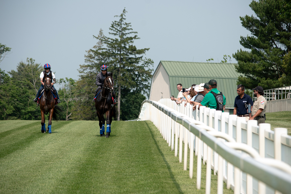 two rider returning from their run, observers on the side watching and taking notes