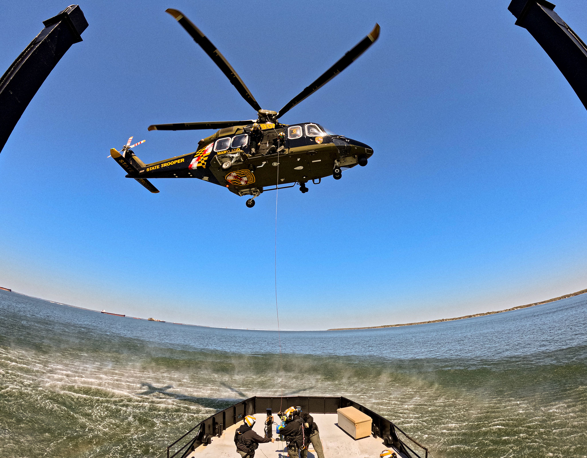 Helicopter hovering over the deck of the A.V. Sandusky a 80 foot icebreaker in the Bay