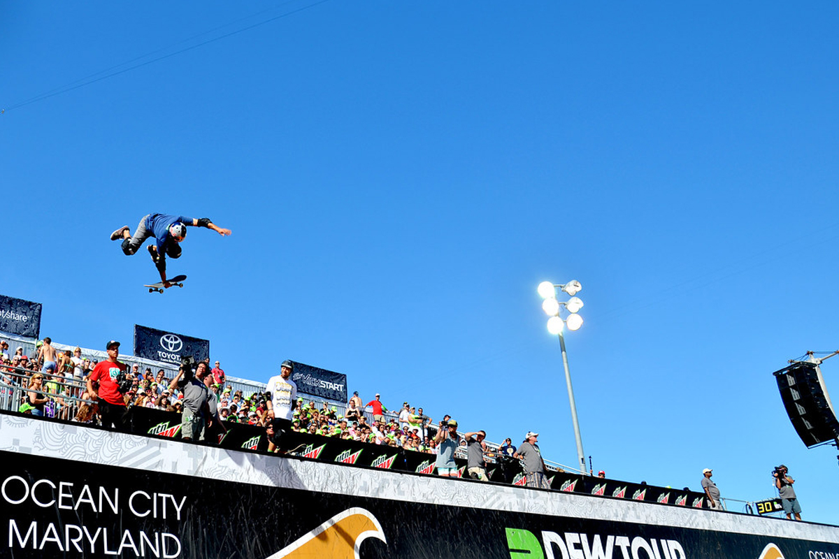 skater flying up over the crowd with the board just in his hand